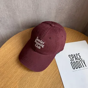 Detailed view of Sunday Running Club embroidery on a burgundy cotton baseball cap
