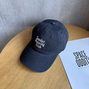 Detail of embroidered Sunday RUNNING CLUB text on navy blue cotton baseball cap