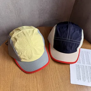 Overhead view of two quick-dry five-panel camping caps with color-blocking and short brims