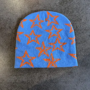 Detailopname van hemelblauwe gebreide muts met contrasterende oranje sterpatronen