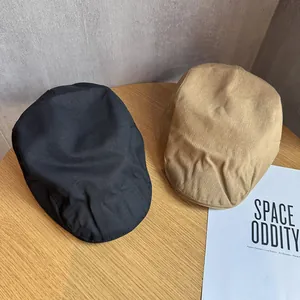 Bérets rétro minimalistes en noir et kaki présentés sur une table ronde en bois