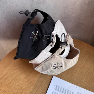 Three lightweight nylon baseball caps in black, cream, and khaki with adjustable drawstrings