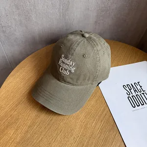 Detail of embroidered Sunday RUNNING Club logo on khaki cotton twill baseball cap