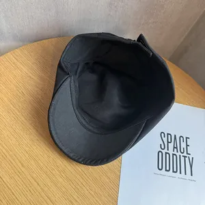 Détail de la structure interne et des coutures fines d'une casquette béret noire
