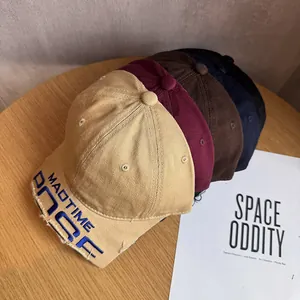 Close-up of distressed brim detail and embroidered letters on cotton baseball caps