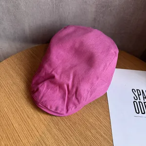 Détail du béret rose pêche montrant la texture fine du tissu et les coutures du bord