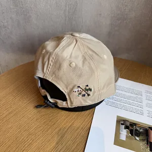 Detail of the embroidery logo and drawstring adjustment on the khaki outdoor baseball cap
