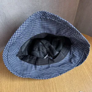 Detail of navy blue plaid bucket hat interior showing stitching and sweatband