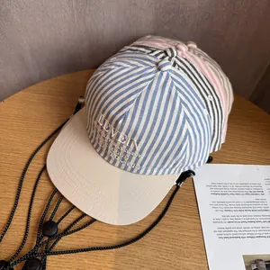 Striped baseball cap with LEVEIN embroidery and adjustable windproof rope on wood