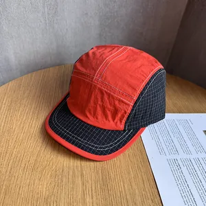 Detail showing the contrast stitching and plaid fabric of this outdoor five-panel camper hat