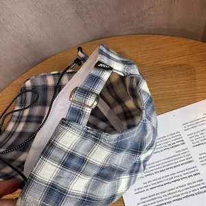 Detail der blau-weiß karierten Baseballkappe mit Metallschnalle und verstellbarem Riemen
