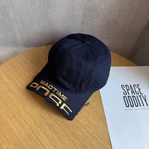 Detail of navy blue washed baseball cap featuring gold MADTIME embroidery and distressed brim