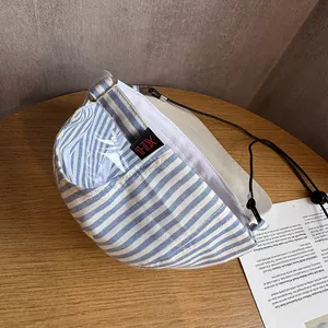 Close-up of blue and white striped canvas bucket hat with adjustable black wind cord and tag