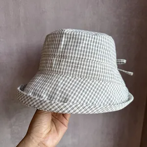 Detailed close-up of checkered sun hat with a decorative bow and fine stitching