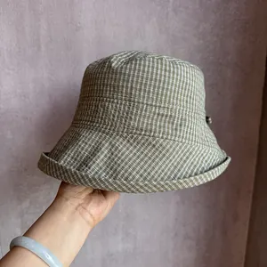 Detailed view of checkered sun hat texture with reinforced brim and adjustment buckle