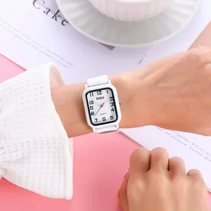 Detail shot of a white square quartz watch with numeric dial and soft silicone strap