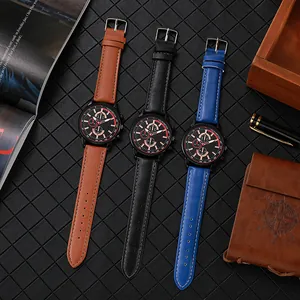 Trois montres à quartz pour hommes avec bracelets en cuir marron, noir et bleu sur un bureau