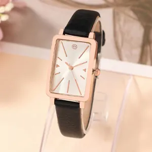 Detailed macro view of a women's rectangular watch with rose gold case and black leather strap