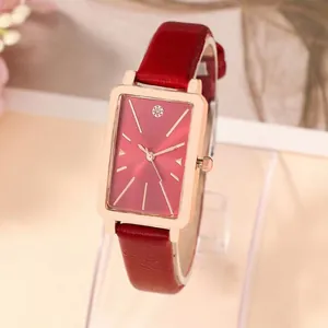 Macro shot of rectangular rose gold quartz watch with a textured burgundy leather strap