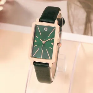 Detail of rectangular rose gold watch with green malachite dial and leather strap
