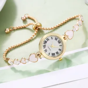 Detail of adjustable gold heart bracelet watch with crystal accents and shell dial