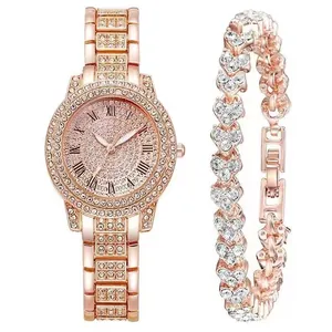 Detail van roségouden horloge en hartarmband met kristallen en Romeinse cijfers erop