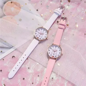 Flat lay detail of cartoon bunny watches with leather straps and sequin background