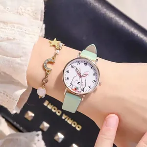 Close-up of mint green rabbit watch with gold star and moon bracelet on wrist