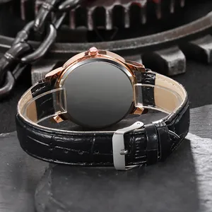 Detail of rose gold watch case with black crocodile embossed leather strap and silver buckle