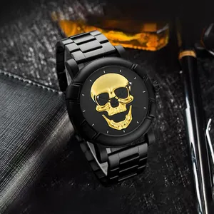 Details einer schwarzen Herrenuhr mit goldenem Totenkopf-Zifferblatt auf dunklem Grund