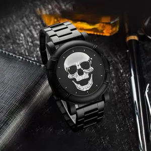 Details einer mattschwarzen Herrenuhr mit Totenkopf auf Lederunterlage und Zubehör