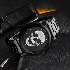 Detail einer schwarzen Quarzuhr mit silbernem Totenkopf-Relief und Metallarmband auf dem Tisch