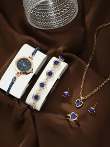 Six-piece gold women's watch and jewelry set with blue heart gemstones on silk fabric