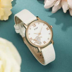 Detail of white leather strap watch with gold case and butterfly dial motif
