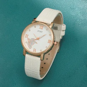 Detailed view of rose gold women's watch with white leather strap and butterfly pattern