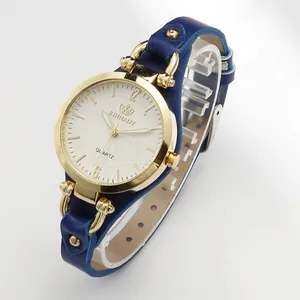 Detailed view of a stylish women's gold quartz watch with a blue studded leather strap.