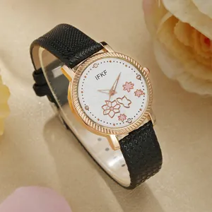 Detail van roségouden horloge met bloemenwijzerplaat en kristallen op zijde stof