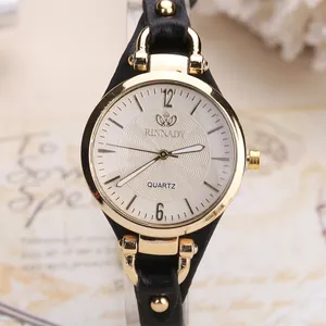 Close-up of a vintage quartz watch with a white textured dial and gold studded leather strap
