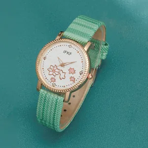 Detailopname van een roségouden horloge met bloemenwijzerplaat en lichtgroene band