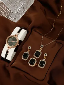 Detail of quartz watch and jewelry set with black gems and crystals on silk fabric