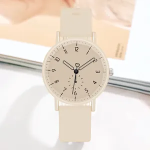 Détail d'une montre à quartz minimaliste avec bracelet en silicone beige et trotteuse en forme de cœur