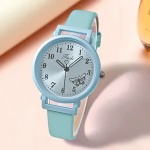 Gros plan d'une montre femme vert menthe avec cadran soleil et motif papillon chic