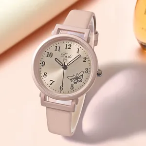 Détail d'une montre à quartz en cuir rose avec motif papillon et cadran brossé