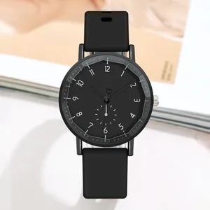 Détail d'une montre à quartz noire avec bracelet silicone et aiguilles en forme de cœur
