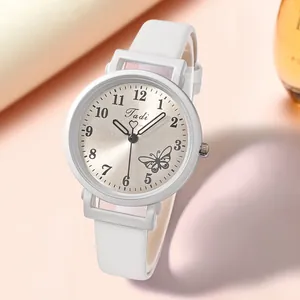 Détail de la montre en cuir blanc avec cadran papillon et chiffres arabes lisibles