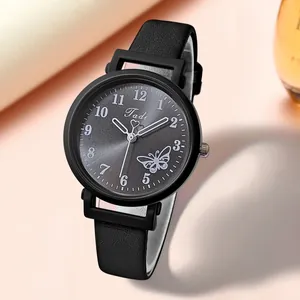 Gros plan sur la montre Tadi avec cadran gris à rayons de soleil et papillons blancs