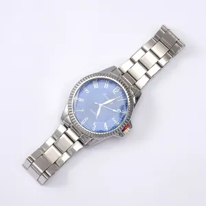 Detail of blue grid dial on silver steel watch with red accent on the crown