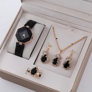 Dettaglio di un set di orologio e gioielli con pietre nere a goccia in scatola
