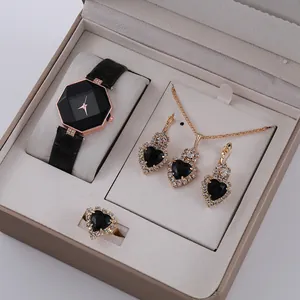 Dettaglio del set di gioielli nero e oro con orologio ottagonale e ciondoli a cuore