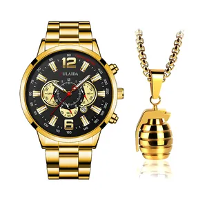 Dettaglio dell'orologio cronografo dorato con quadrante nero e collana con ciondolo granata